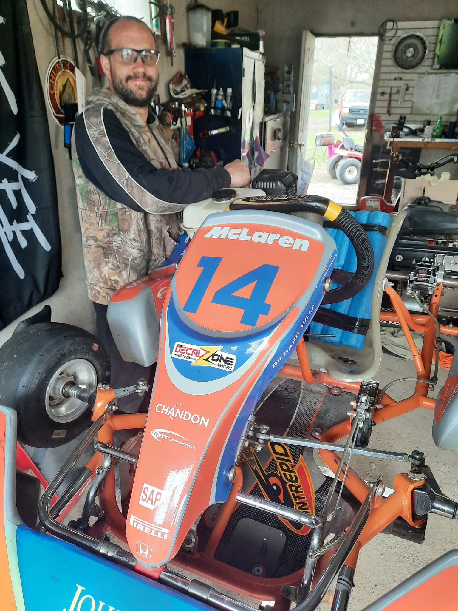Travis Campbell with racing go-kart in the Campbell's Small Engines workshop